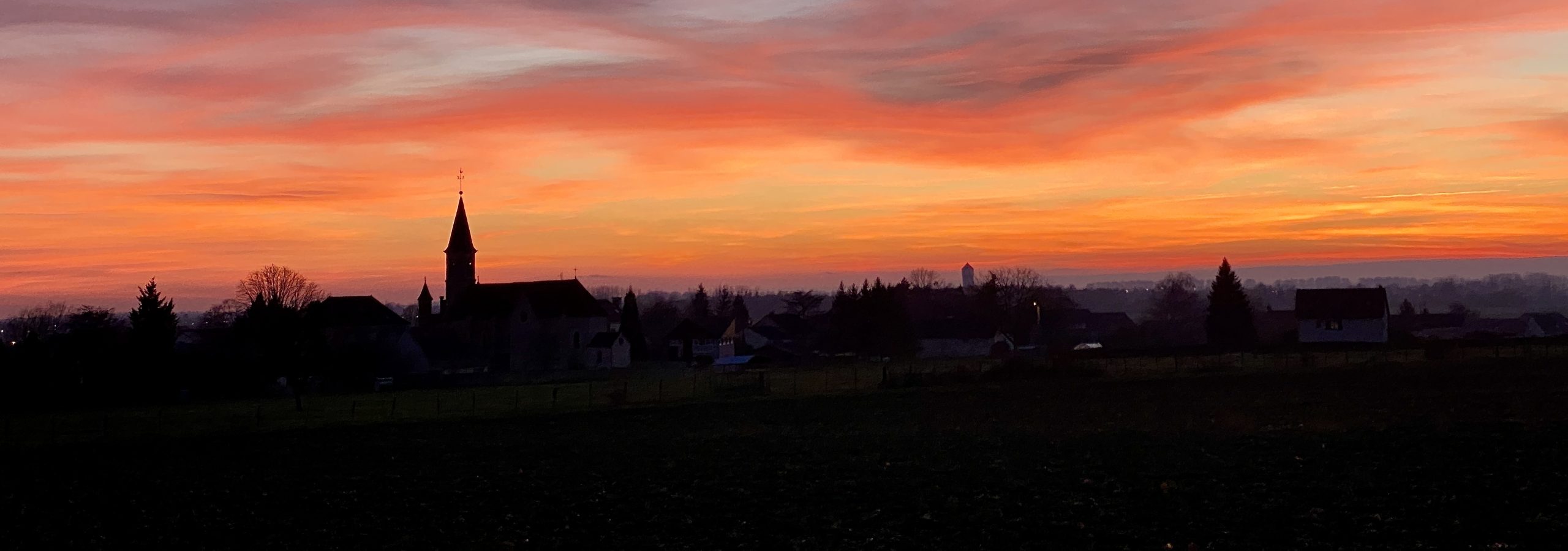 Vue de Villebichot et de son église au coucher du soleil.